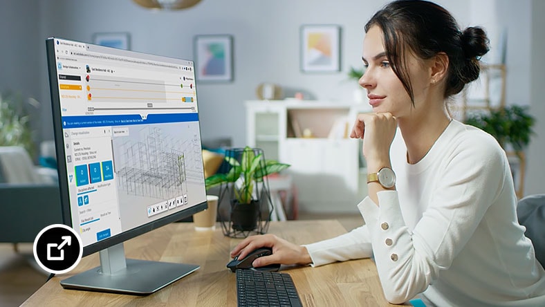 Woman sitting at a desk viewing her computer screen while using BIM Collaborate software